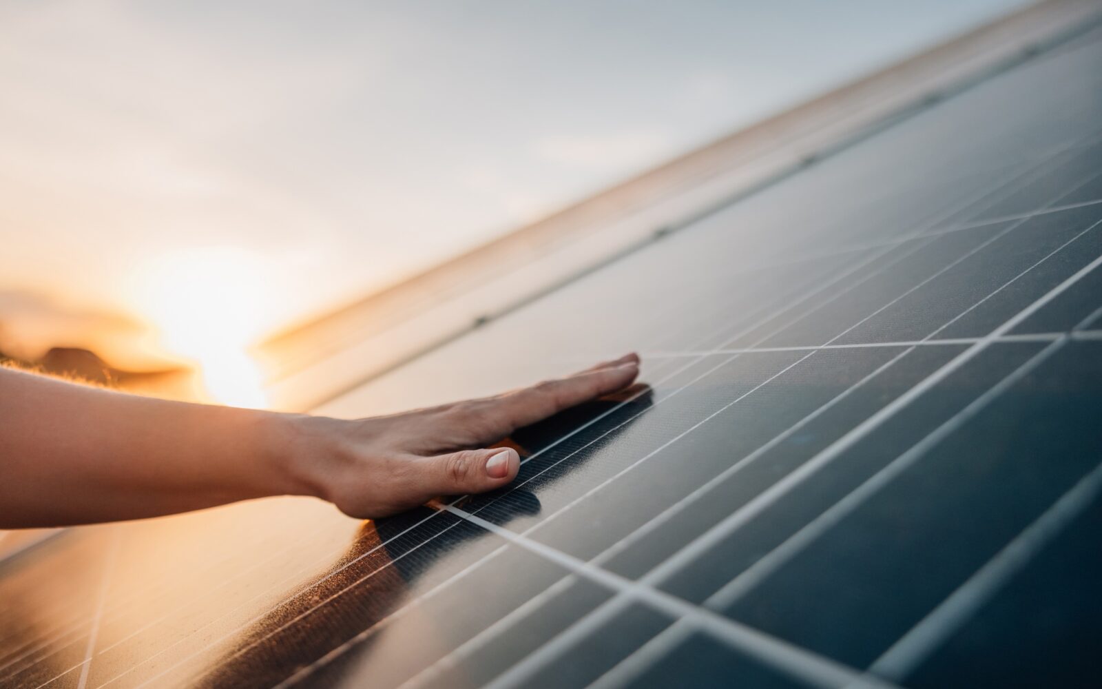 Eine Hand berührt ein Solarpanel
