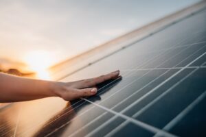Eine Hand berührt ein Solarpanel