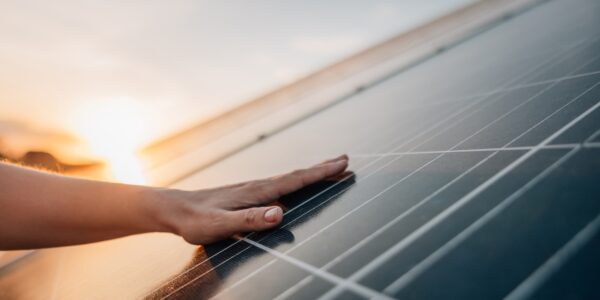 Eine Hand berührt ein Solarpanel
